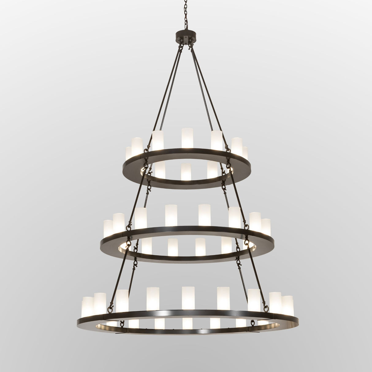 Lit view of the chandelier featuring illuminated glass lights on bronze rings.