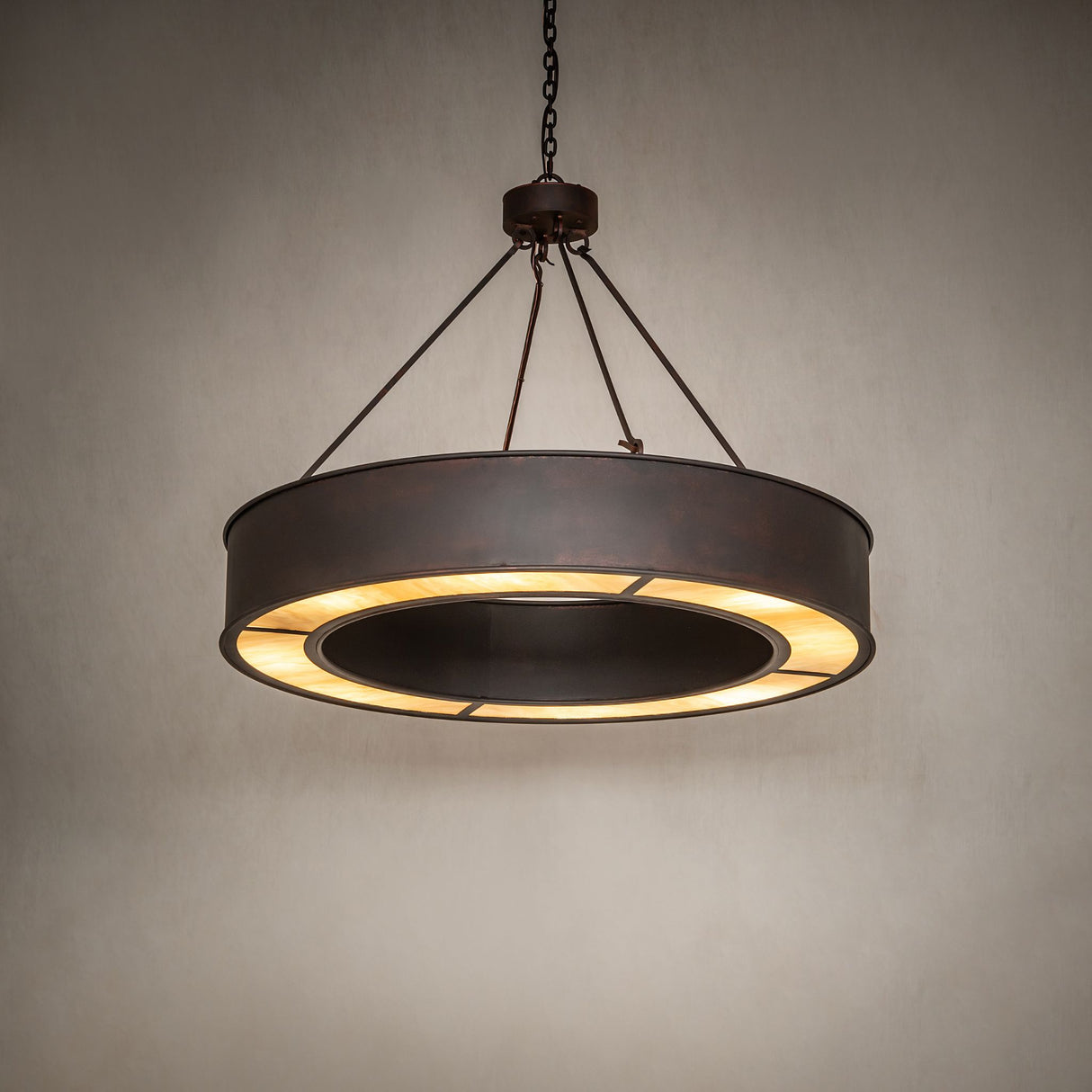 Escabroso chandelier ambient view showing warm illumination and circular travertine diffuser.