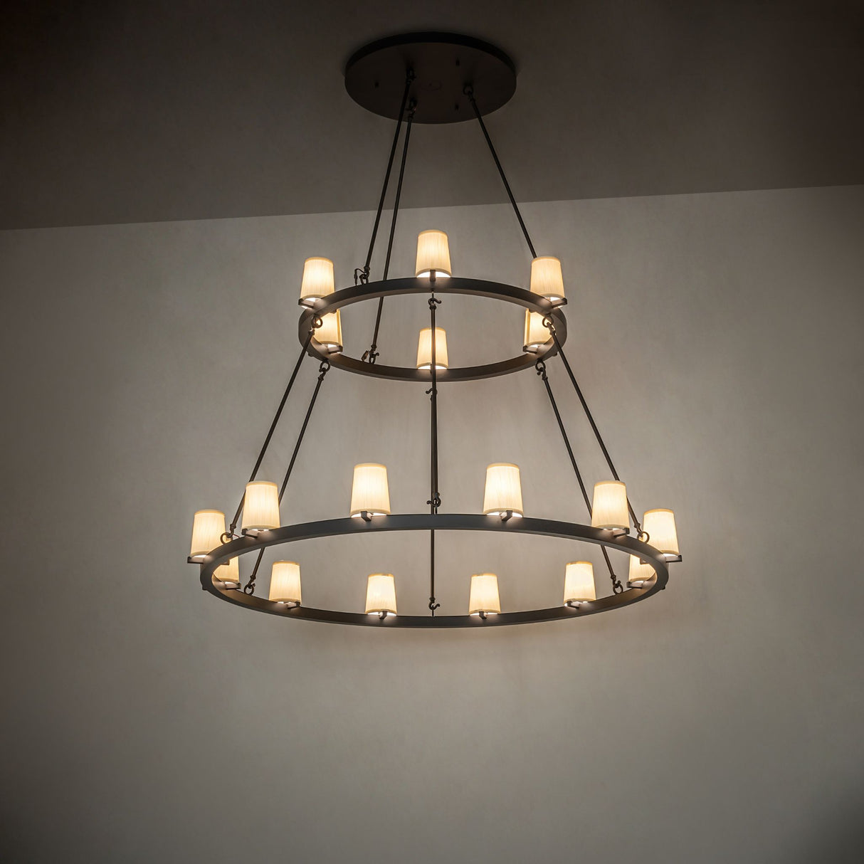 Loxley two tier 18 light chandelier glowing in interior ambient setting.