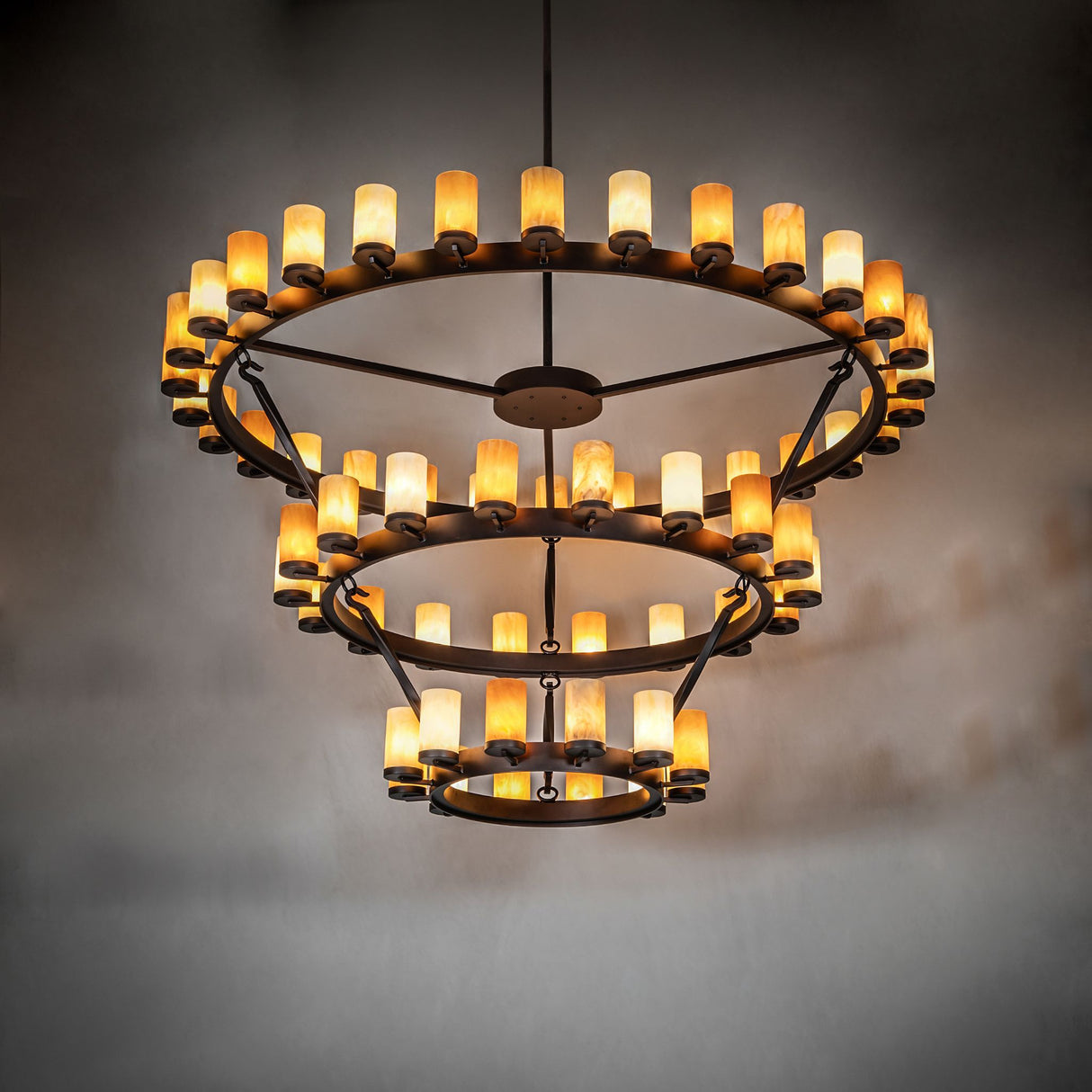 Noziroh three-tier ring chandelier providing warm ambient lighting in a large interior space.