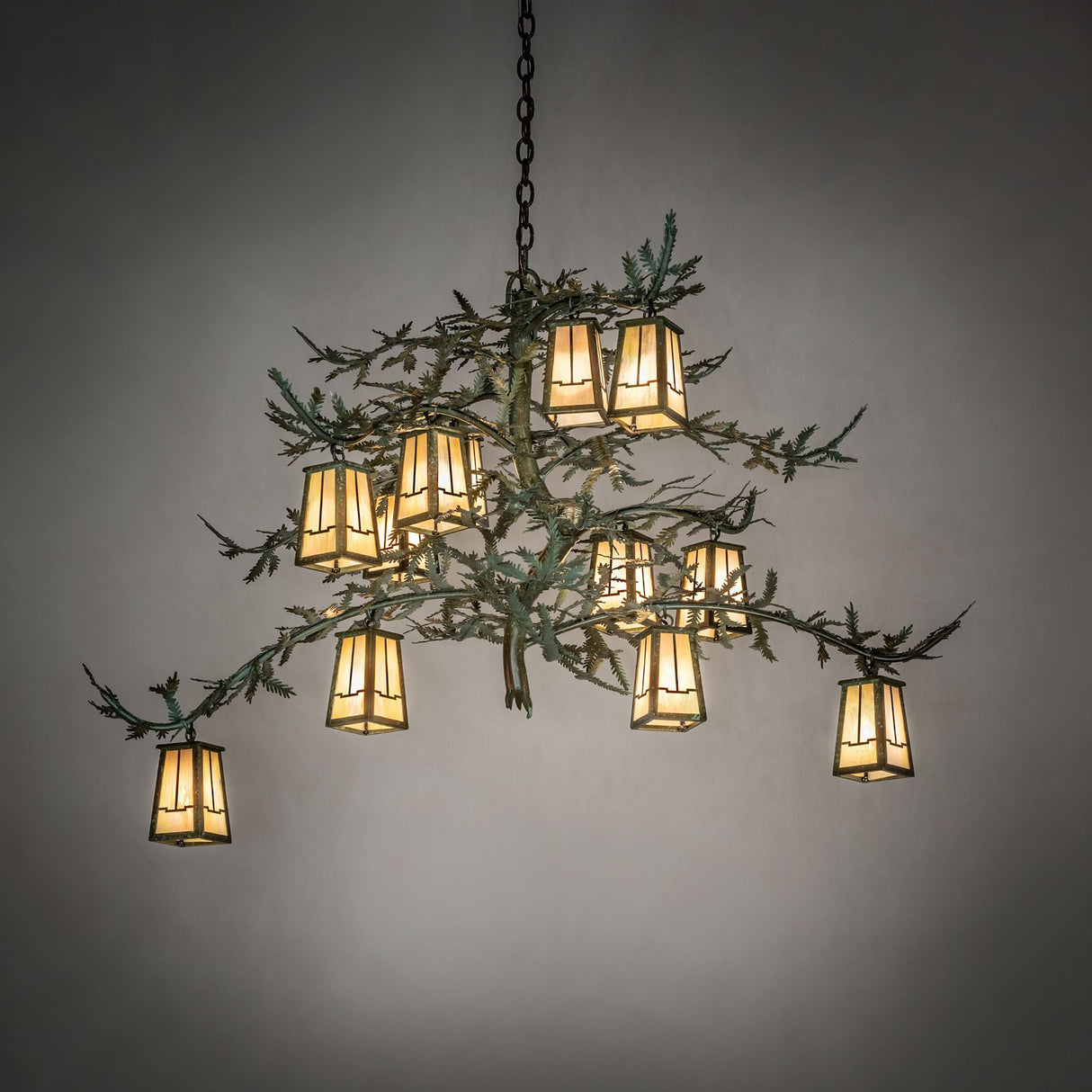 Pine branch chandelier shown glowing in a warm ambient room setting.