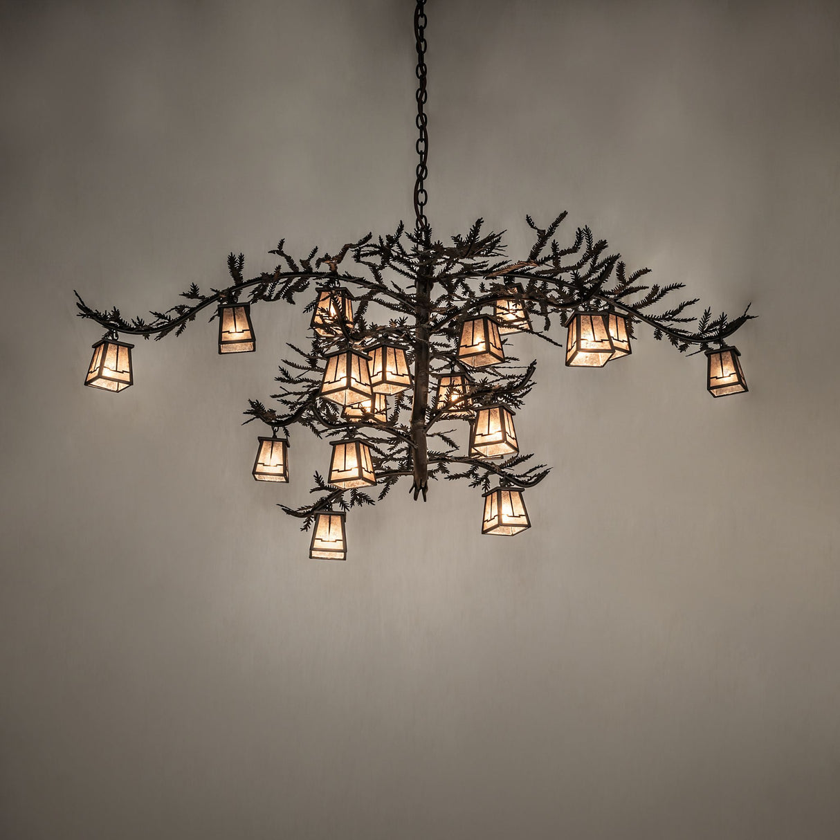 Pine Branch chandelier lit with warm ambient glow highlighting pine branch arms.
