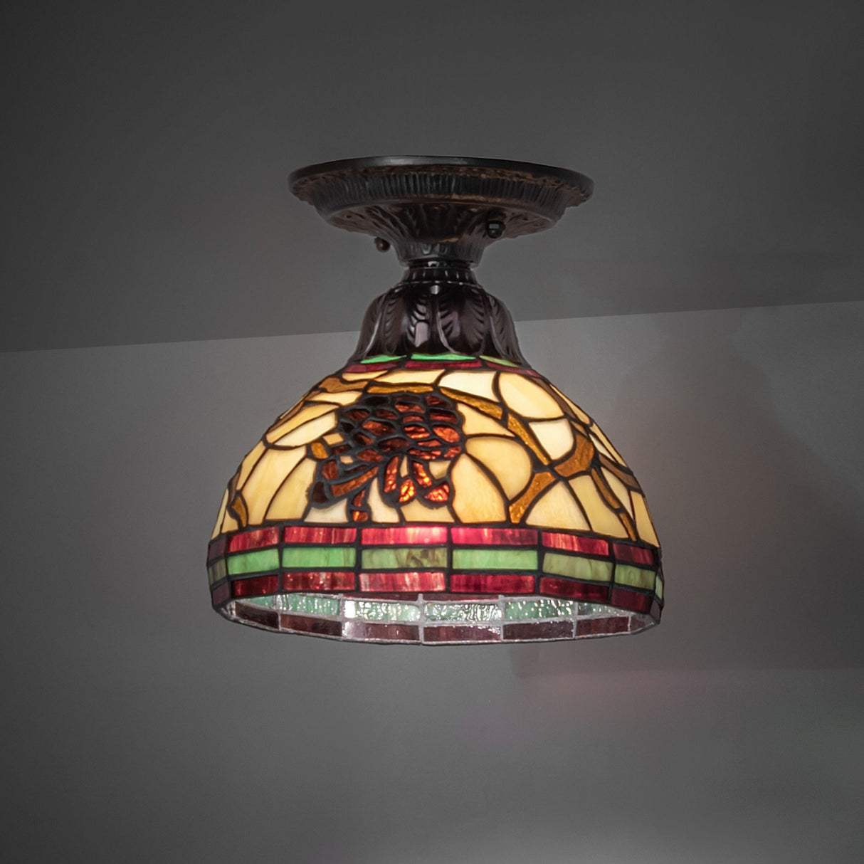 Pinecone Flushmount illuminated, showcasing its warm stained glass glow.