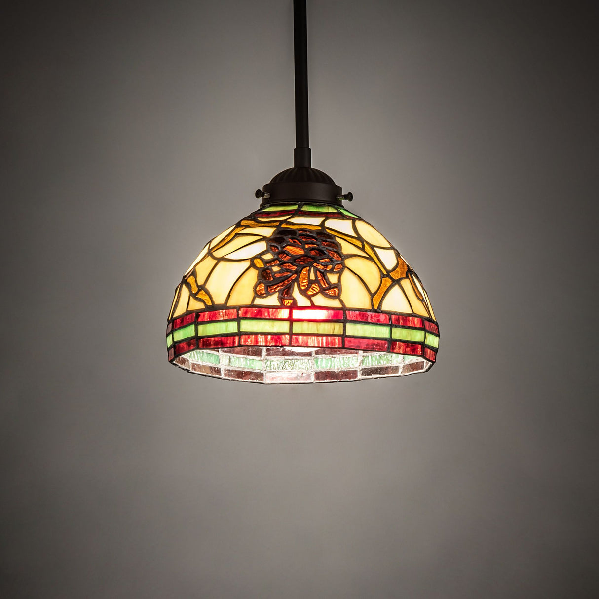 Illuminated front view of the 7.5" wide Pinecone mini pendant showcasing its warm glow.