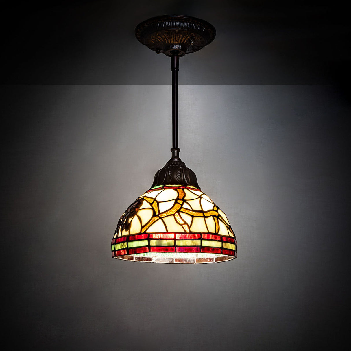 Pinecone mini pendant light glowing in a dark room.