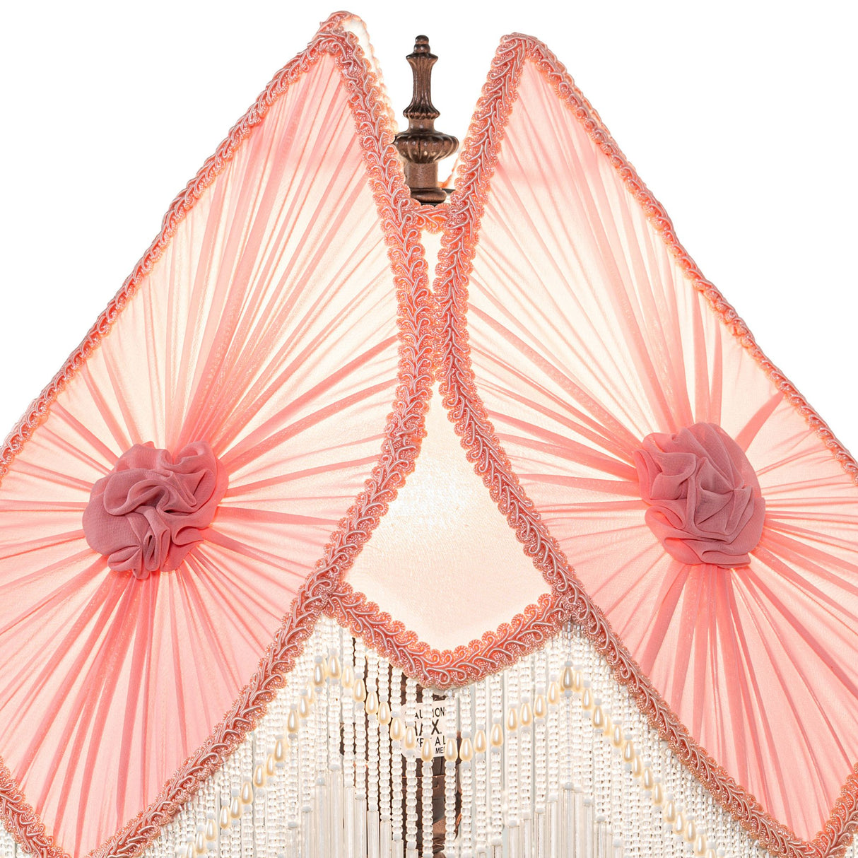 Close-up of pink lampshade with floral accents and fringe detailing.