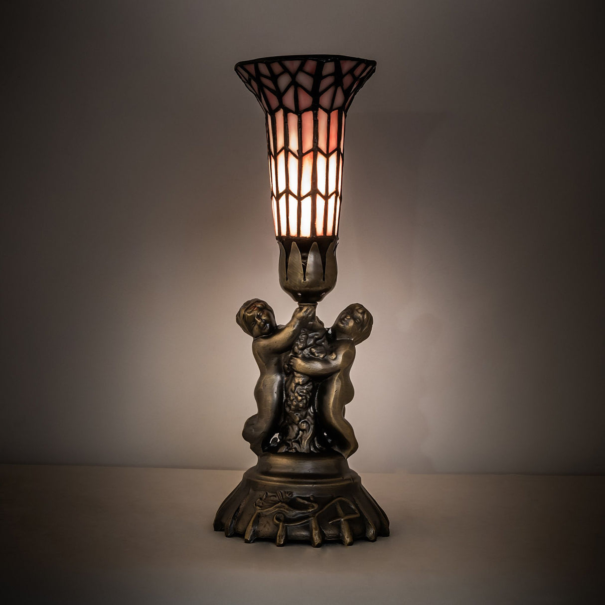 Illuminated stained glass twin cherub accent lamp with warm glow.