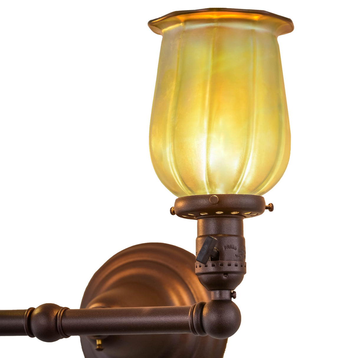 Close-up lit view of the Revival Chelsea Favrile wall sconce showing intricate shade details.