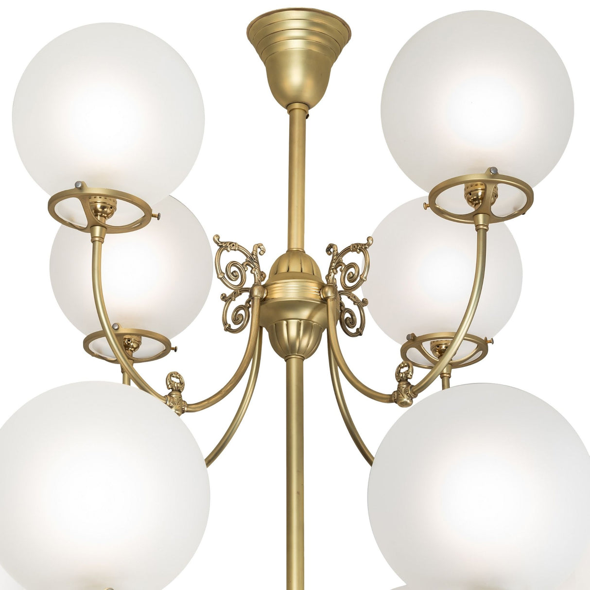 Close-up of polished brass Revival chandelier center with ornate scrollwork.