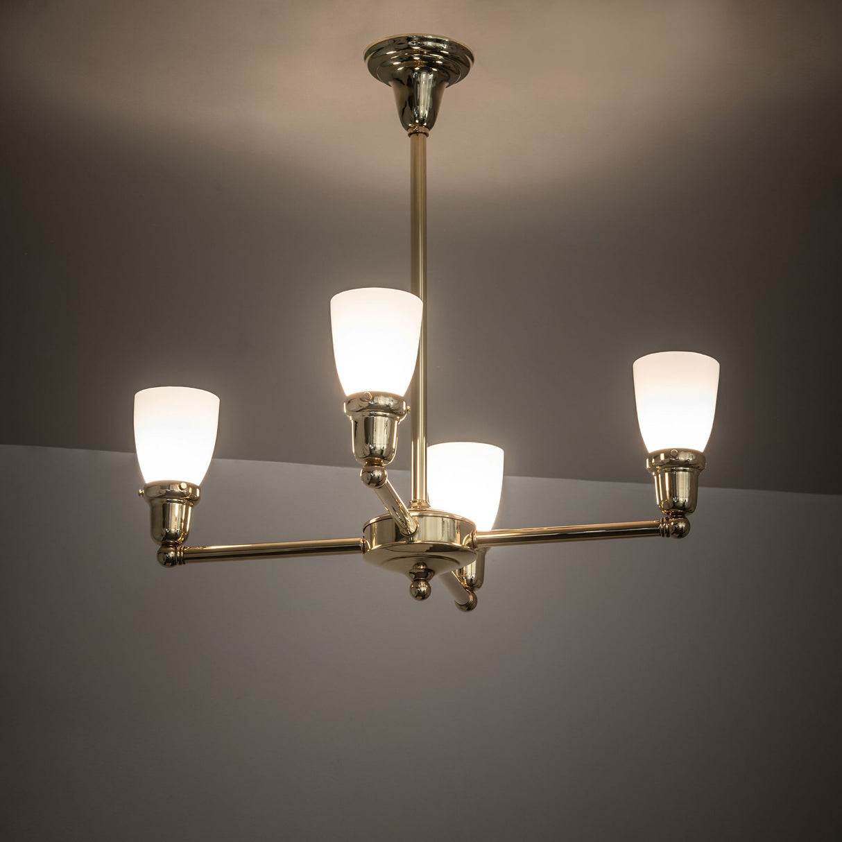Illuminated Revival Oyster Bay chandelier casting soft light.