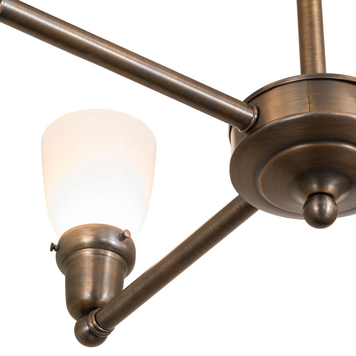 Close-up of antique brass chandelier arm with frosted goblet shade.