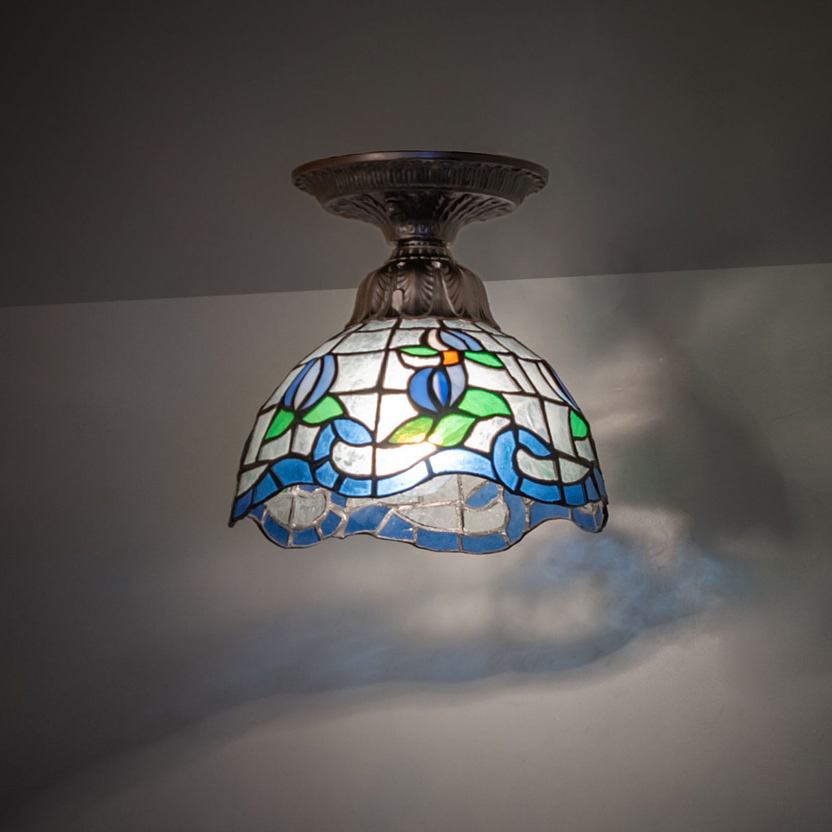Roseborder Flushmount ceiling light lit, showcasing vibrant stained glass colors.