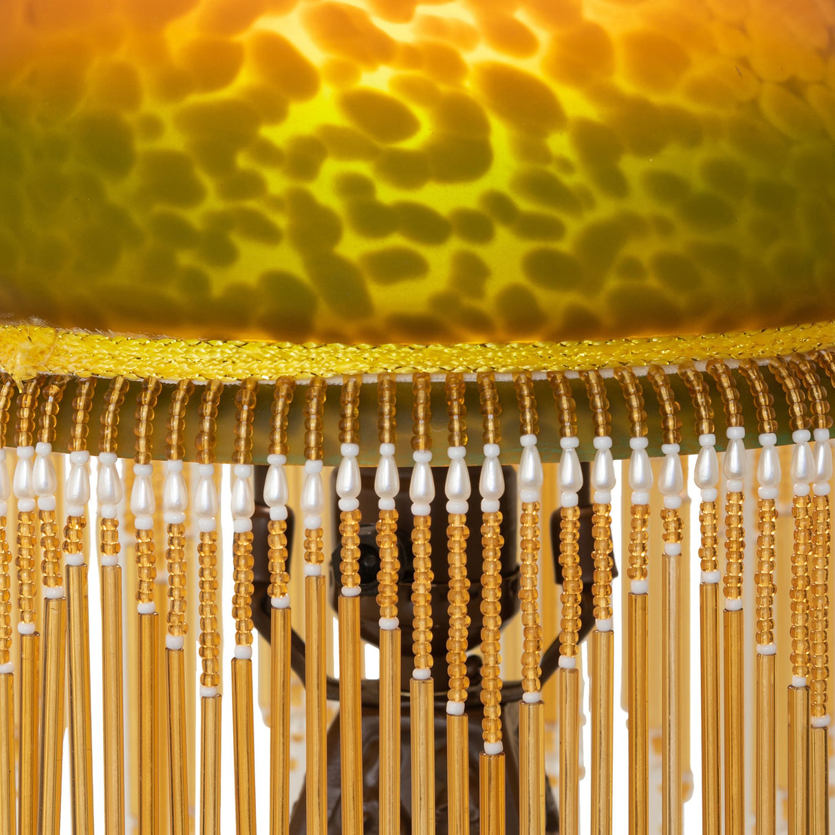 Close-up of the Amber and Green mottled glass shade with white and cranberry beaded fringe.