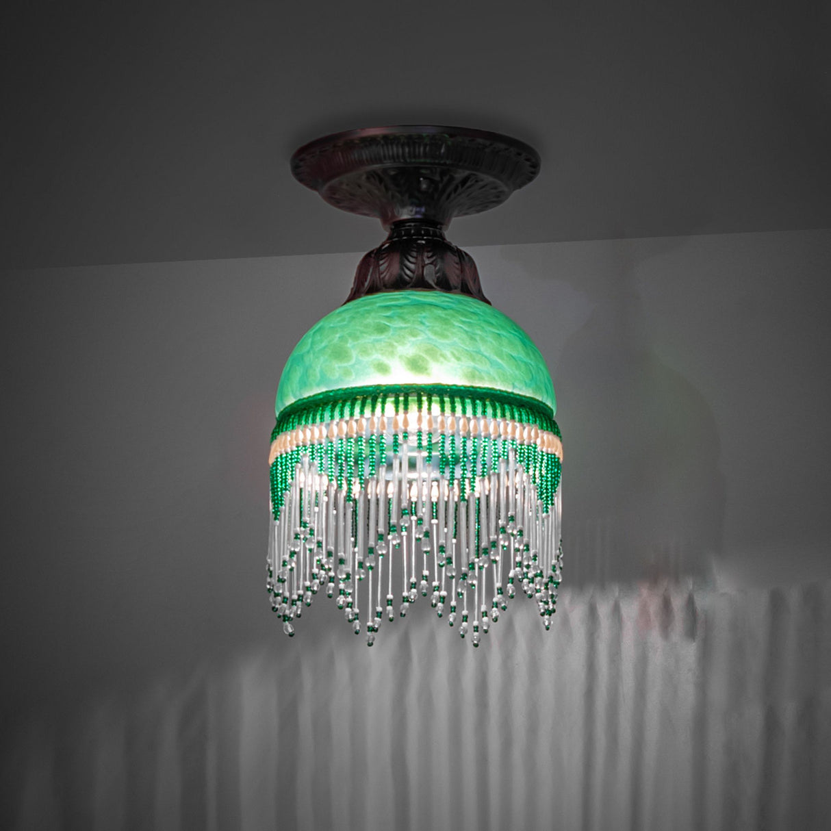 Illuminated Roussillon flushmount showcasing its intricate green design.