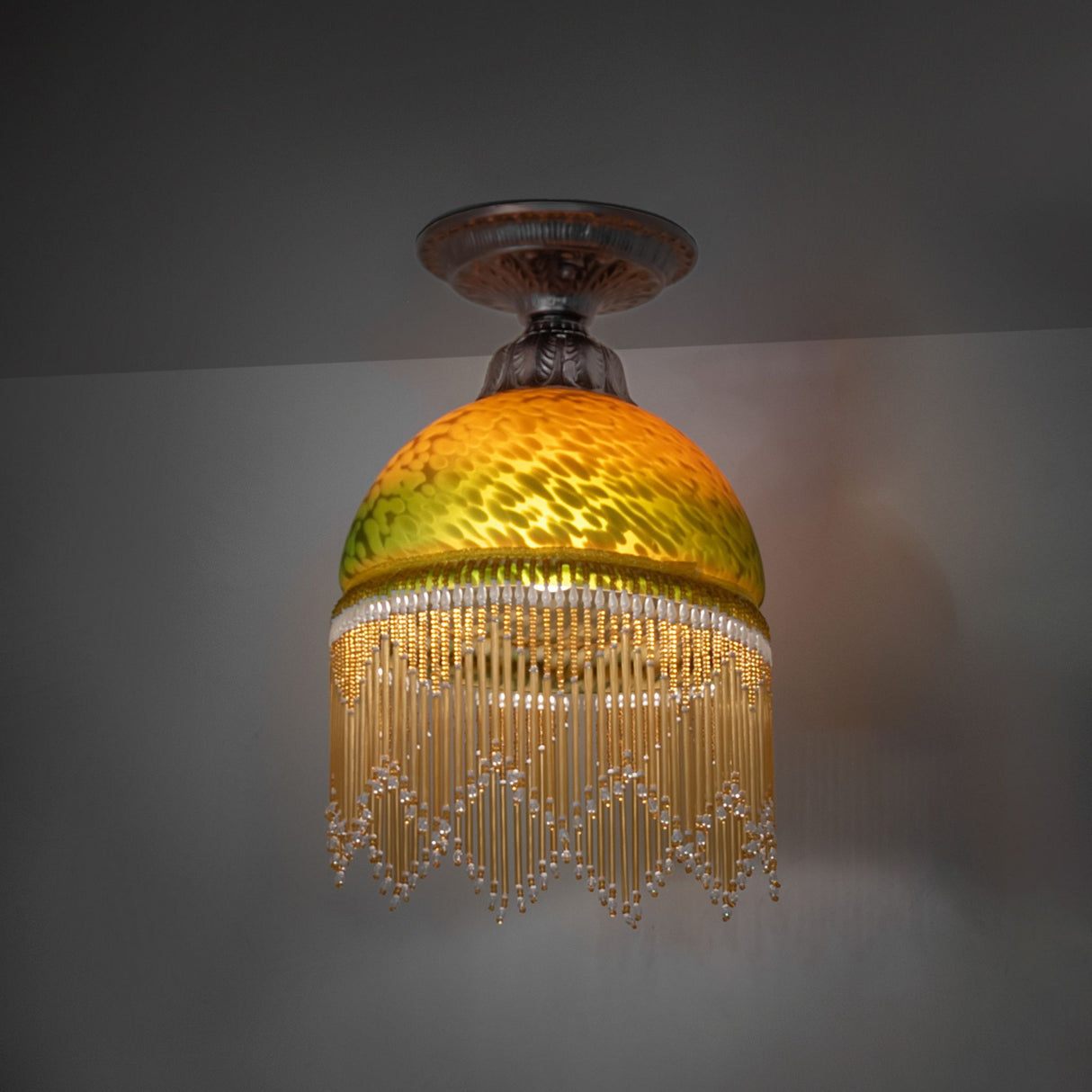 illuminated dark view of roussillon flushmount showcasing elegant amber-green glass.