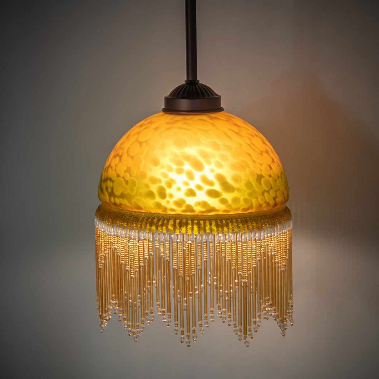 Ambient view of amber mottled glass pendant casting a cozy ambient glow.