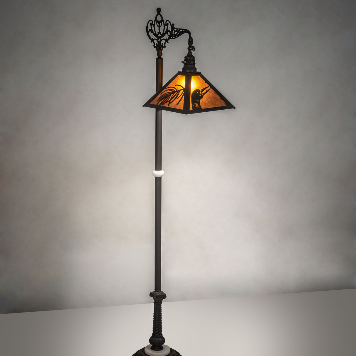 Loon pine needle floor lamp glowing warm amber light in ambient setting.