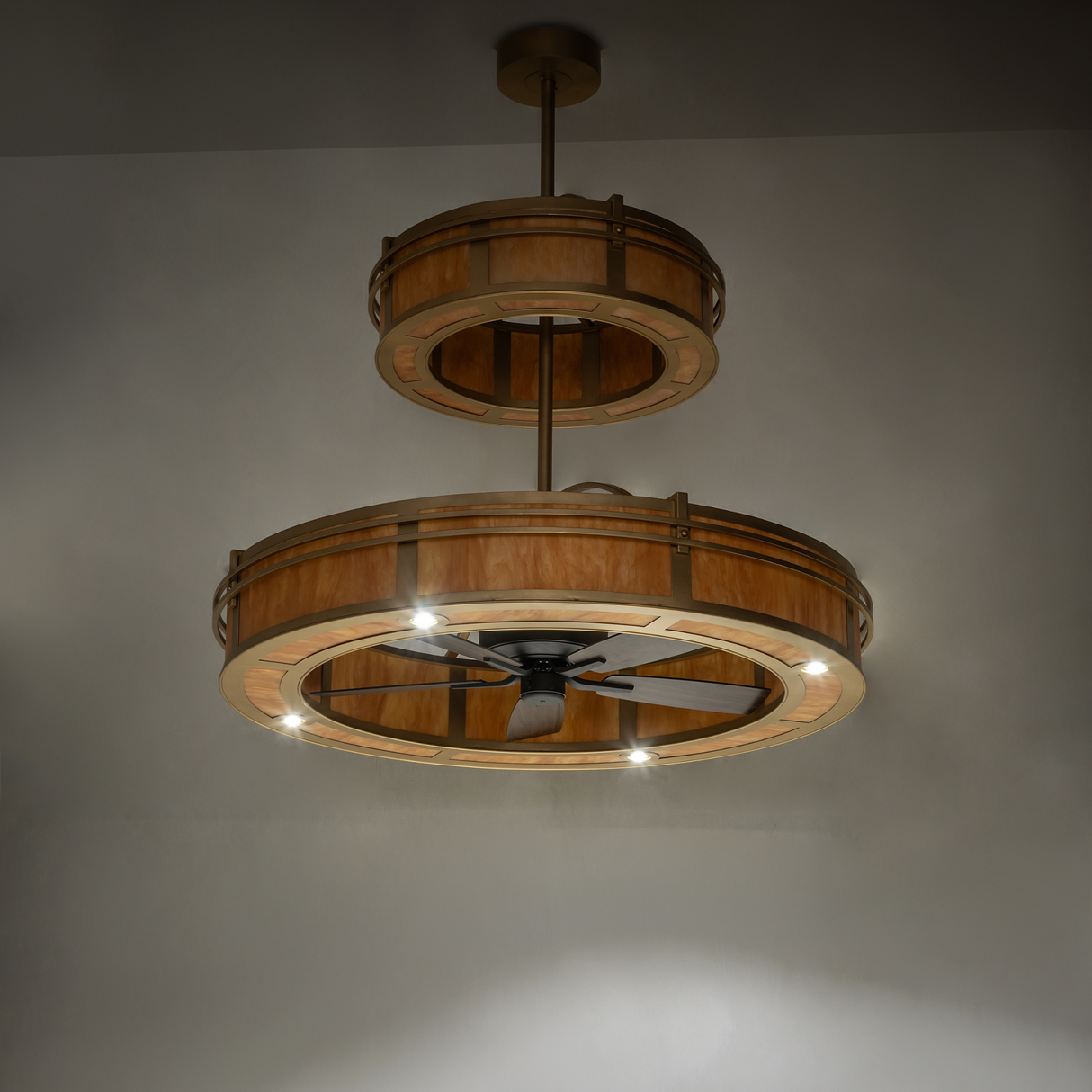 Illuminated angle view showing Sargent chandelier fan’s gold finish and design.