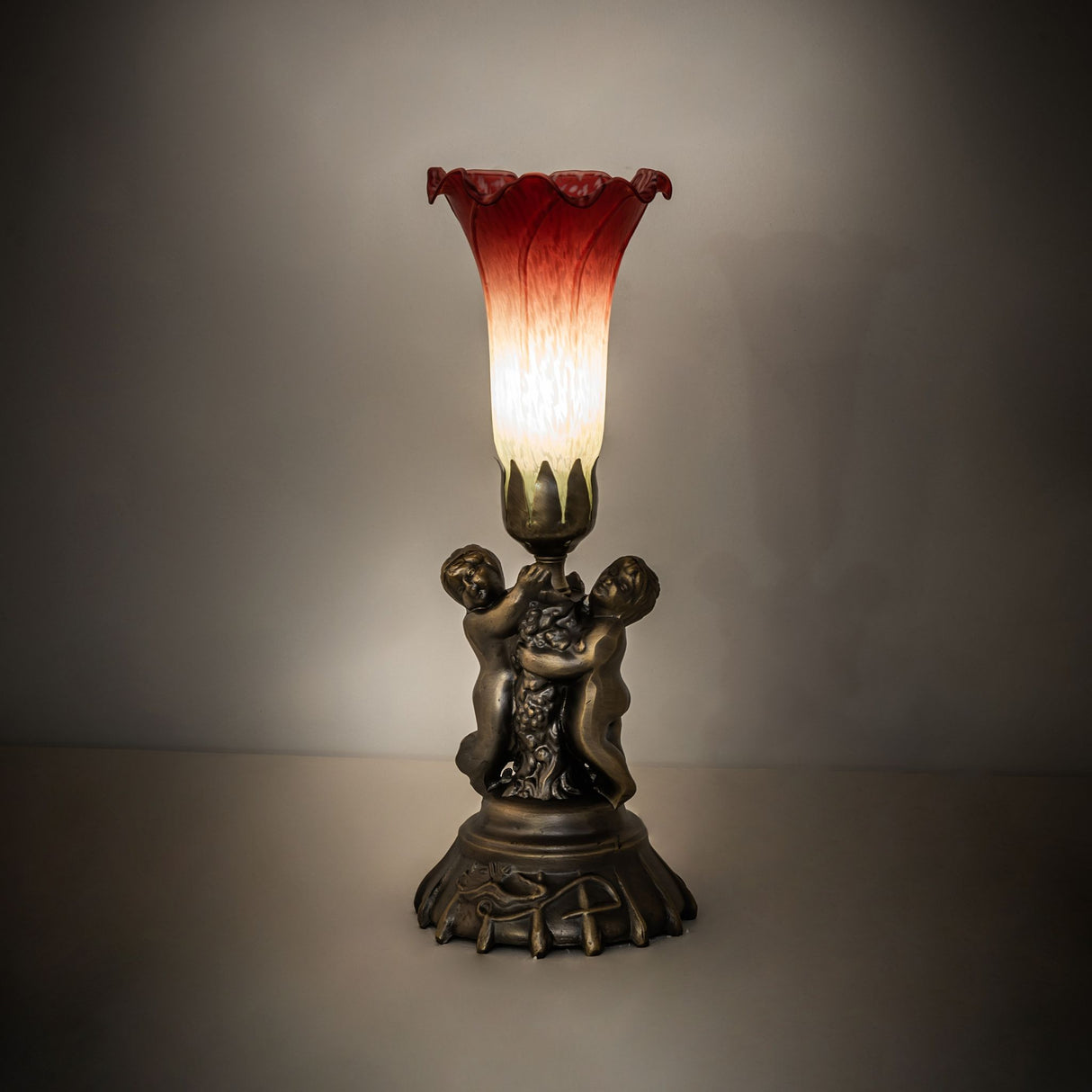 Ambient view of twin cherub lamp glowing in a dim setting.