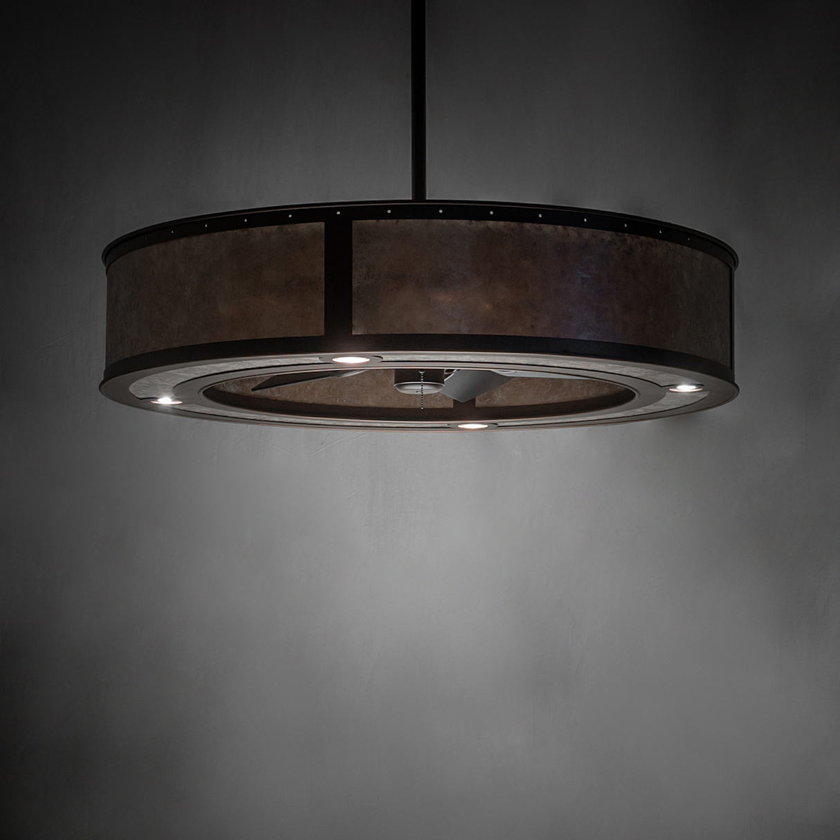Smythe Craftsman chandelier fan emitting faint golden light in moody setting.