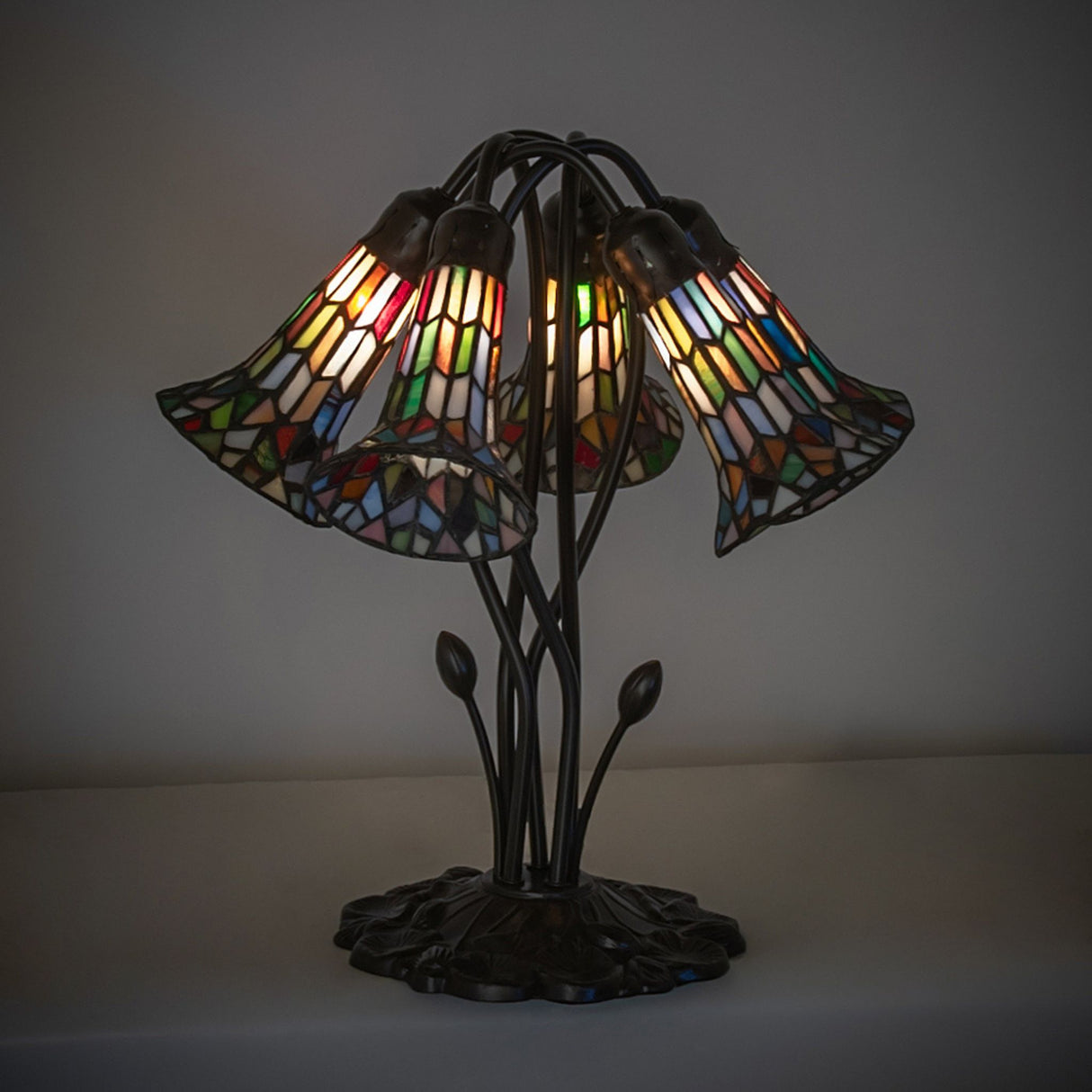 Illuminated stained glass pond lily lamp showcasing intricate multicolored patterns.
