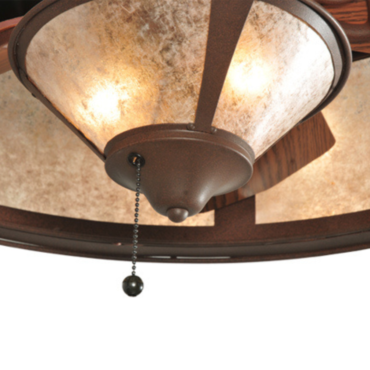 Close-up of fan light with glowing mica diffuser and pull chain.
