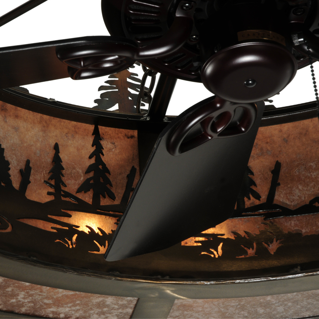 Close-up of fan blades beneath illuminated mica forest design.