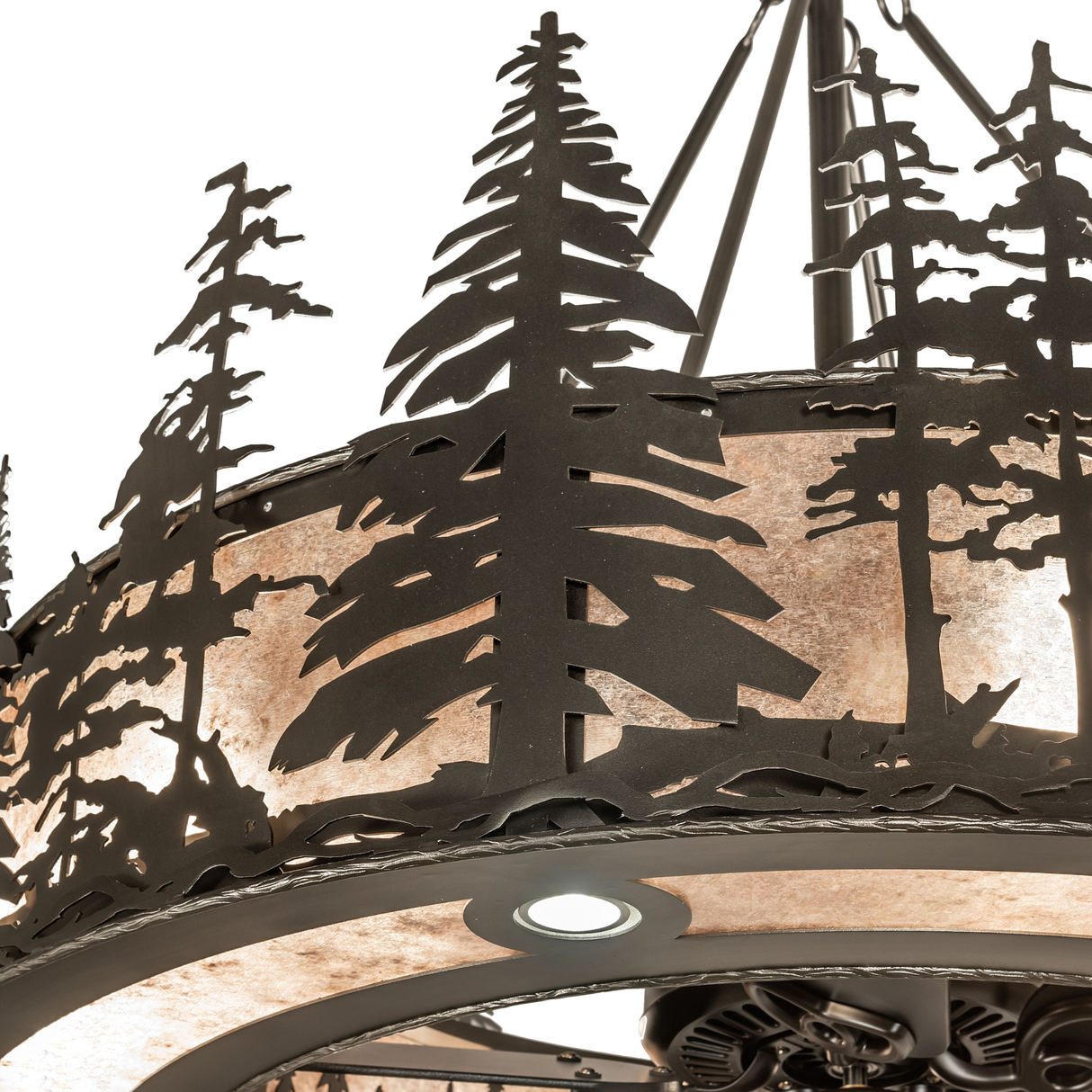 Close-up of handcrafted pine tree silhouettes on mica diffuser surface.