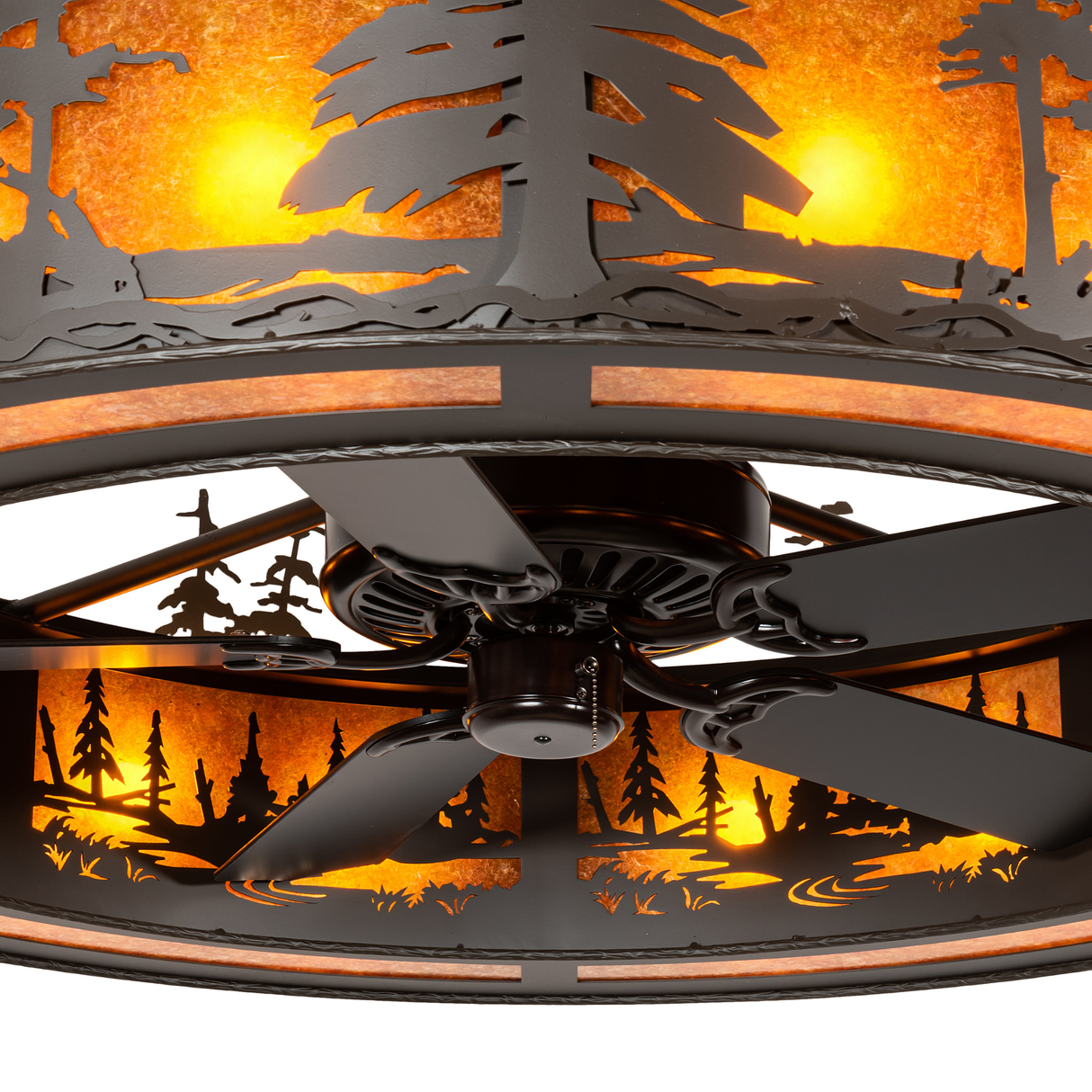 Close-up of fan and pine cutouts illuminated by amber light.