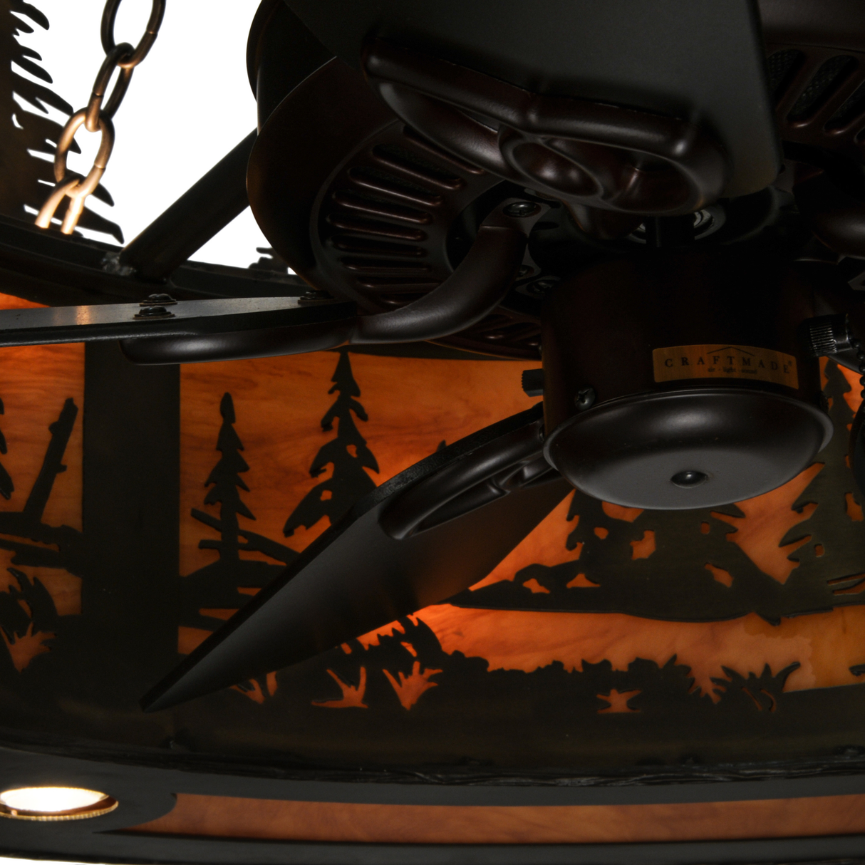 Closeup of fan motor and blades against glowing forest pattern.