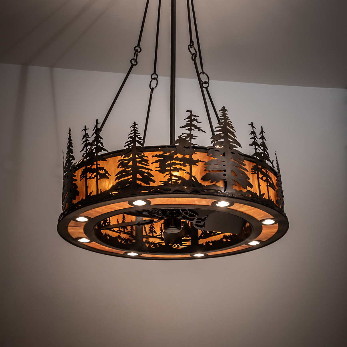 Tall Pines Chandel-Air illuminating rustic space with warm amber light.