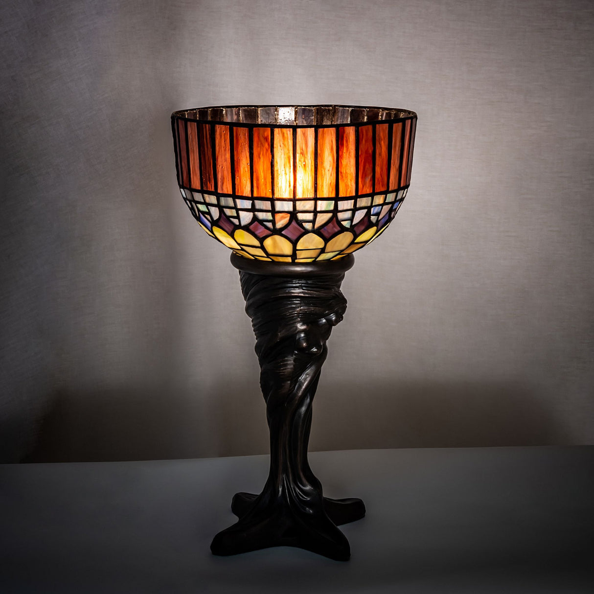 Mini Lamp illuminated in a dim setting, showcasing its warm glow and elegant design.