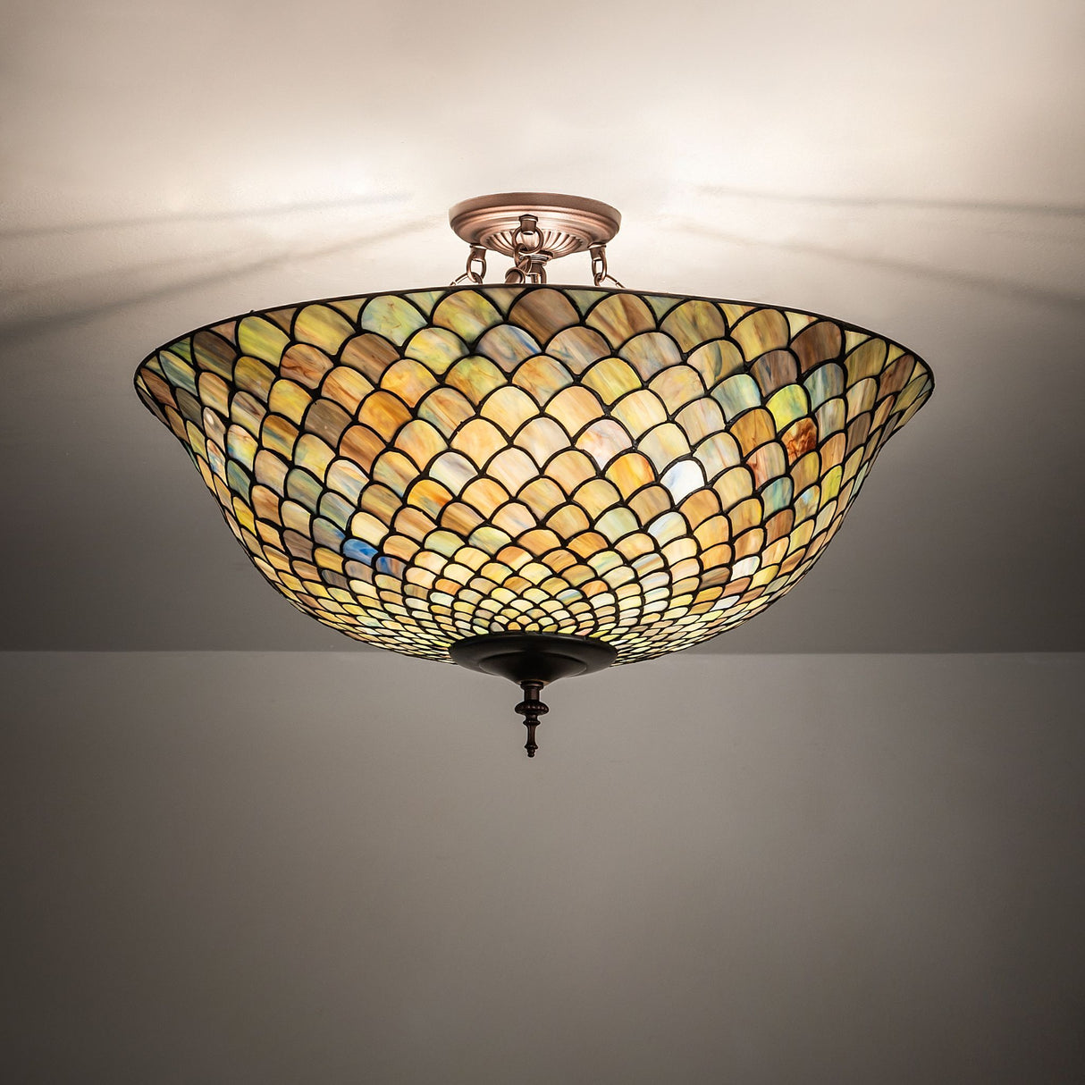 illuminated dark view of tiffany fishscale flushmount with vibrant hues.