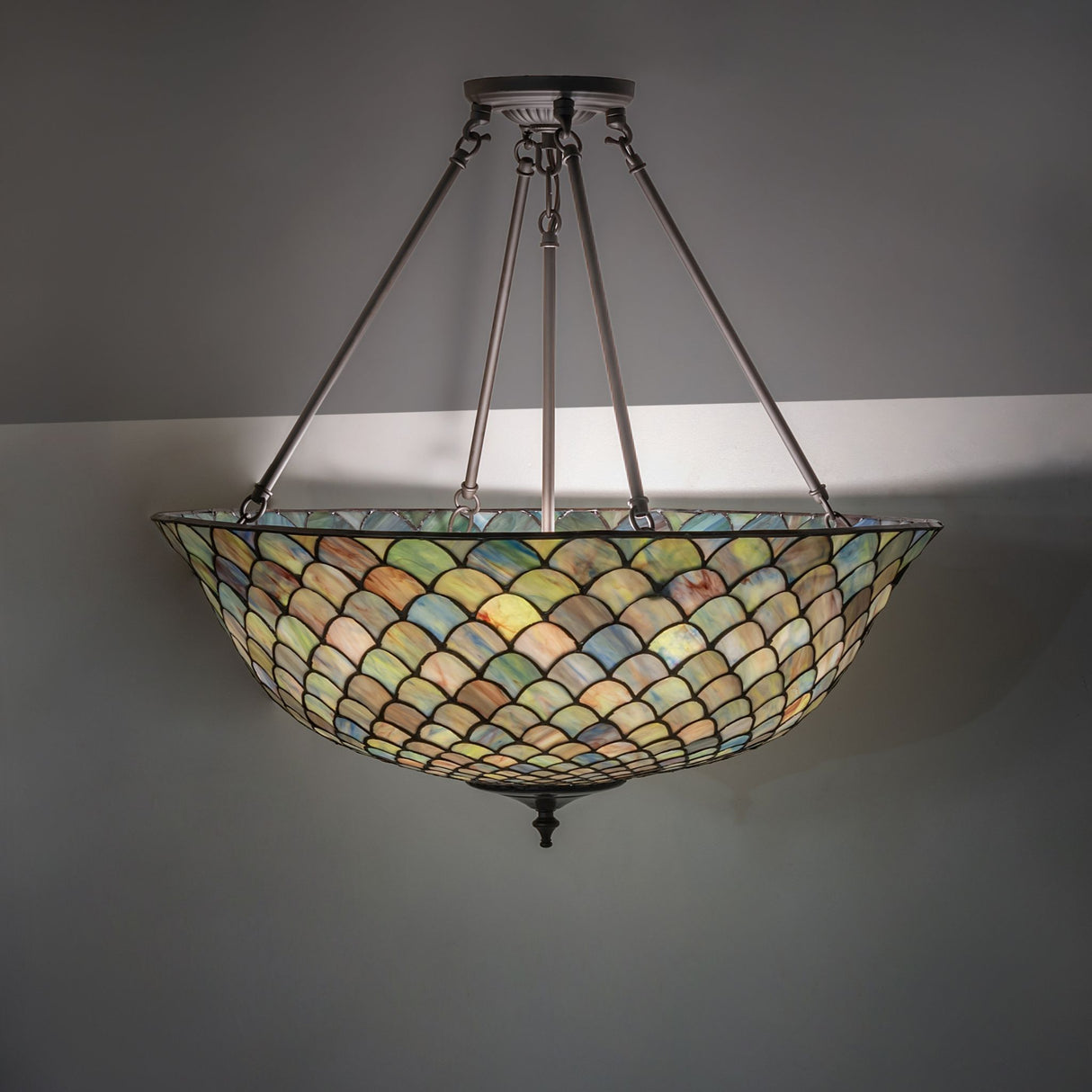 Tiffany Fishscale semi-flushmount illuminating a space with warm light.