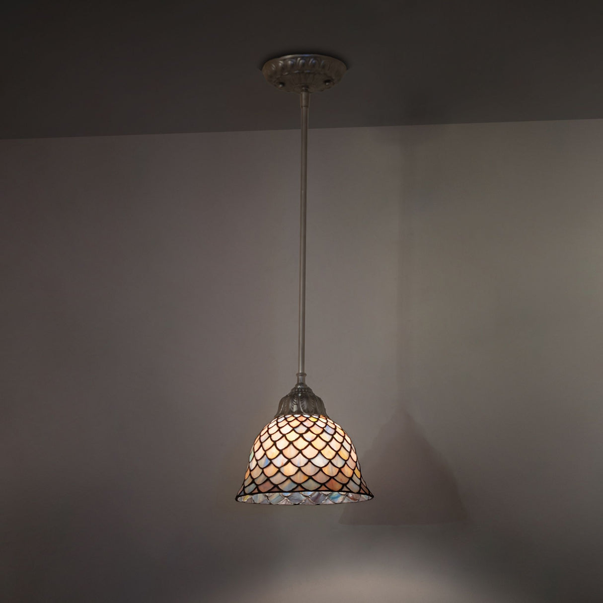 Illuminated Tiffany Fishscale mini pendant showcasing vibrant glass colors.