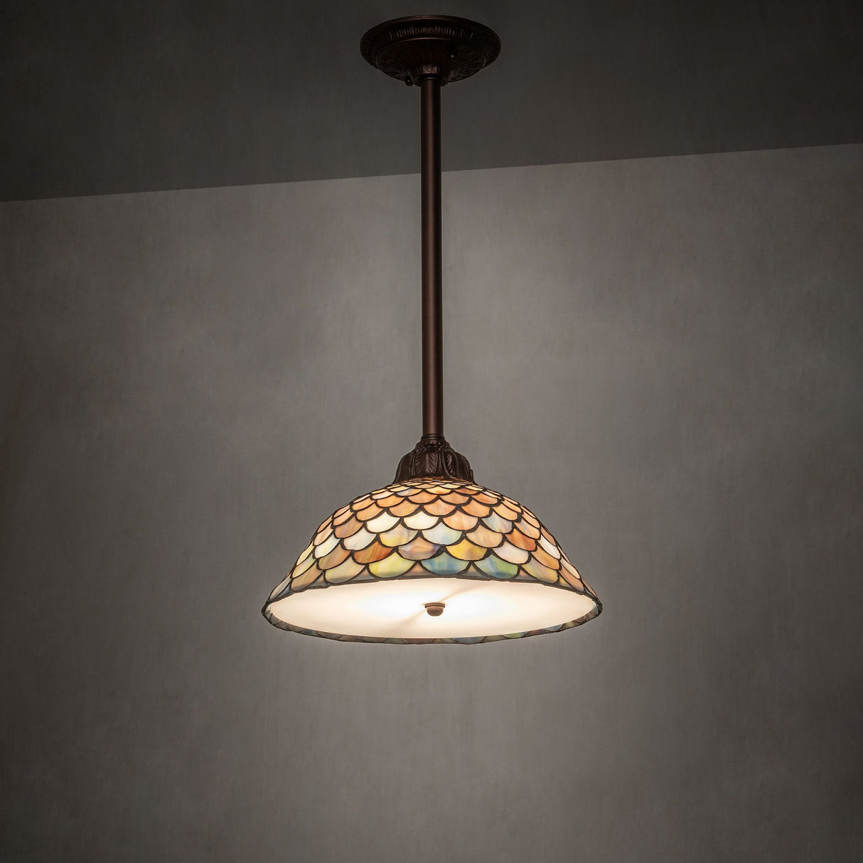 illuminated dark view of tiffany fishscale pendant with vibrant hues.