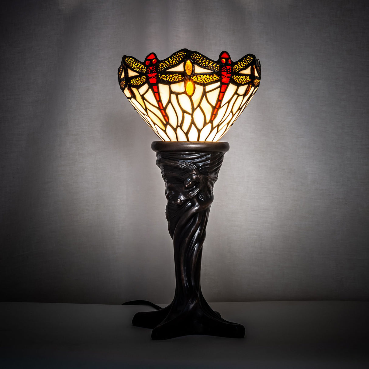 Tiffany dragonfly mini lamp illuminated in warm light.