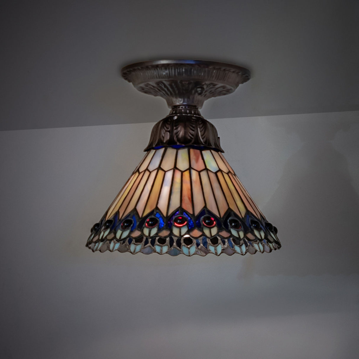 Ambient light view of Tiffany Jeweled Peacock flushmount.