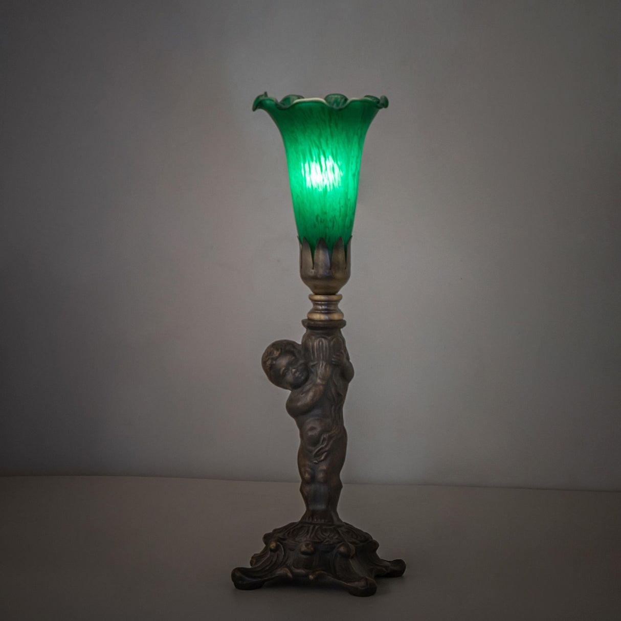 Tiffany Pond Lily Cherub Mini Lamp softly glowing in an ambient setting.