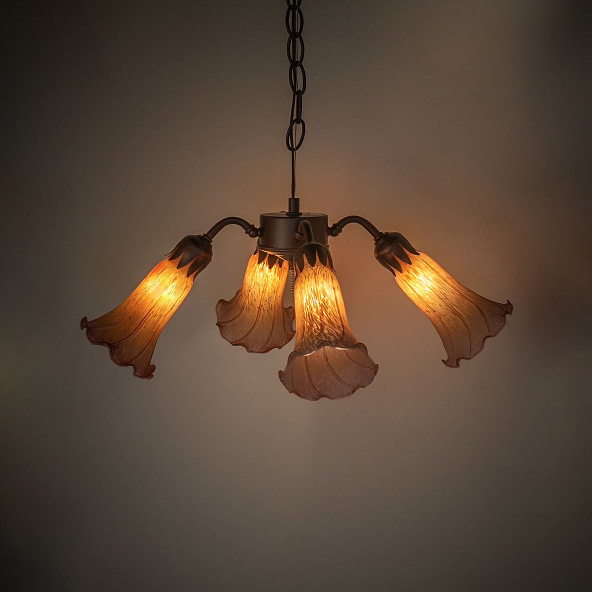 Illuminated view of the Tiffany Pond Lily fan light, showcasing its warm amber glow.