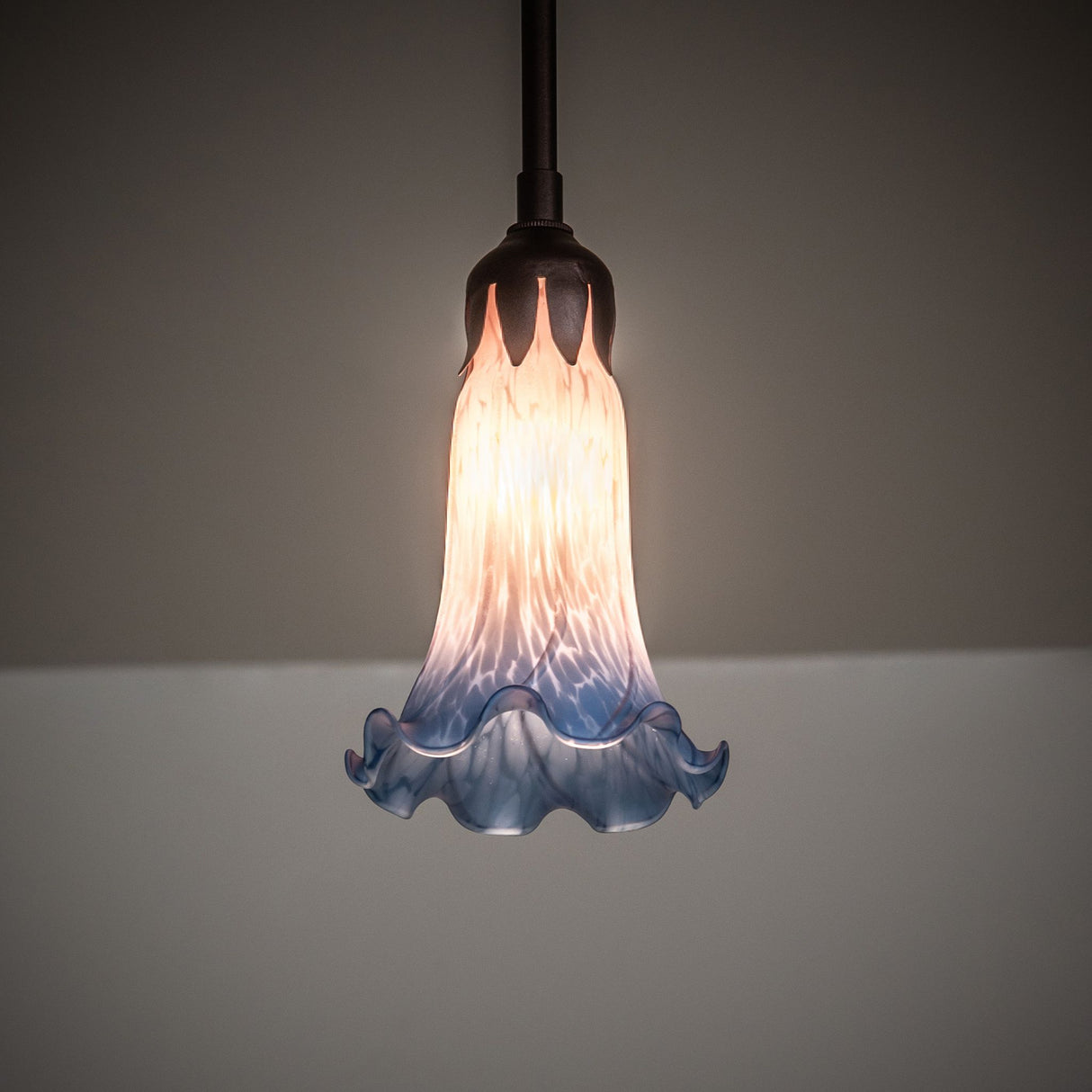 Illuminated Pink and Blue Tiffany Pond Lily mini pendant with warm glow.
