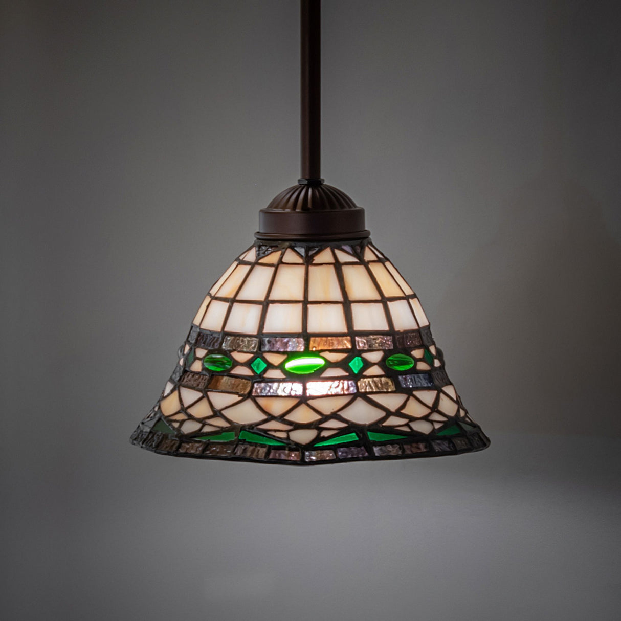 Tiffany Roman mini pendant casting a warm glow in an ambient setting.