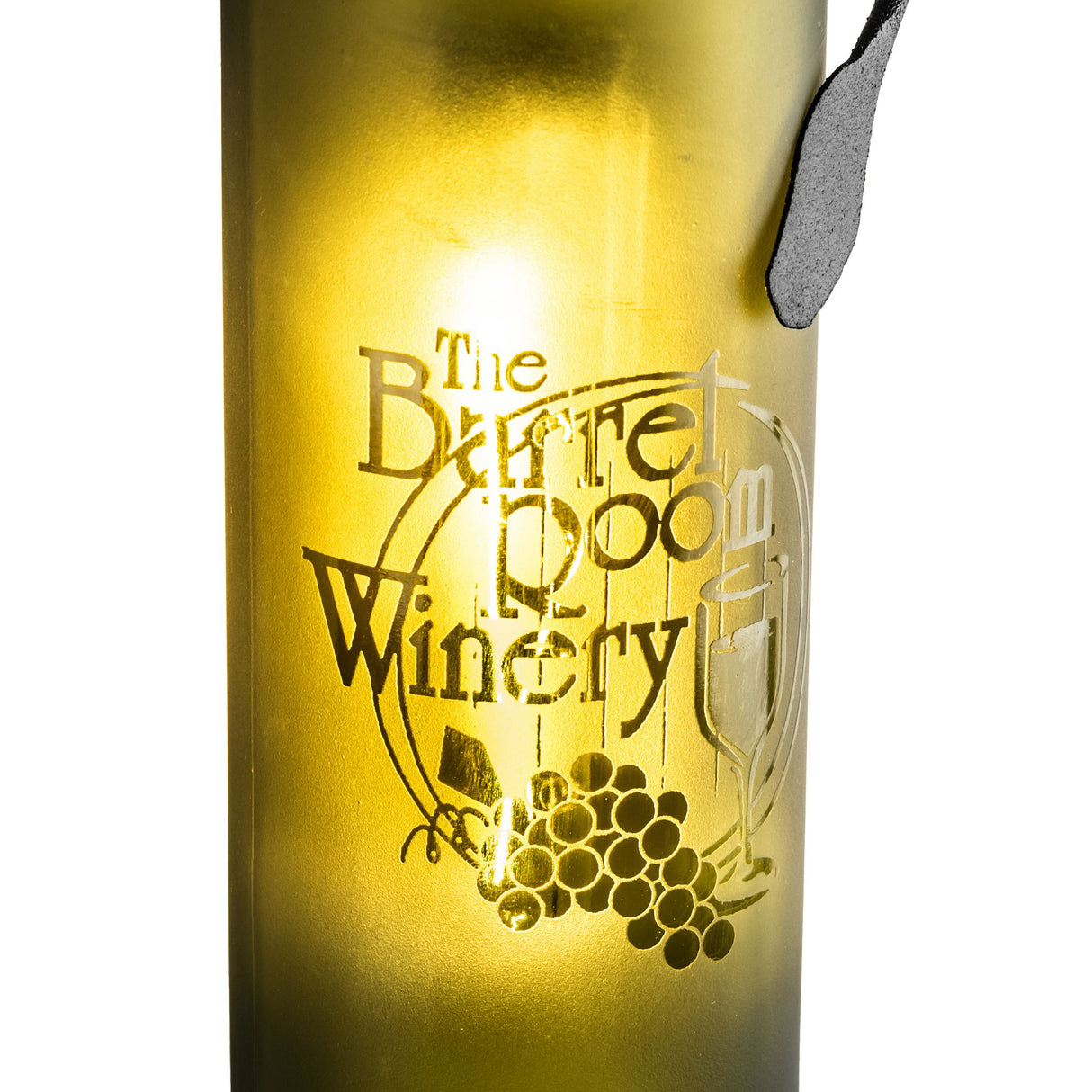 Close-up of etched vineyard logo on wine bottle.