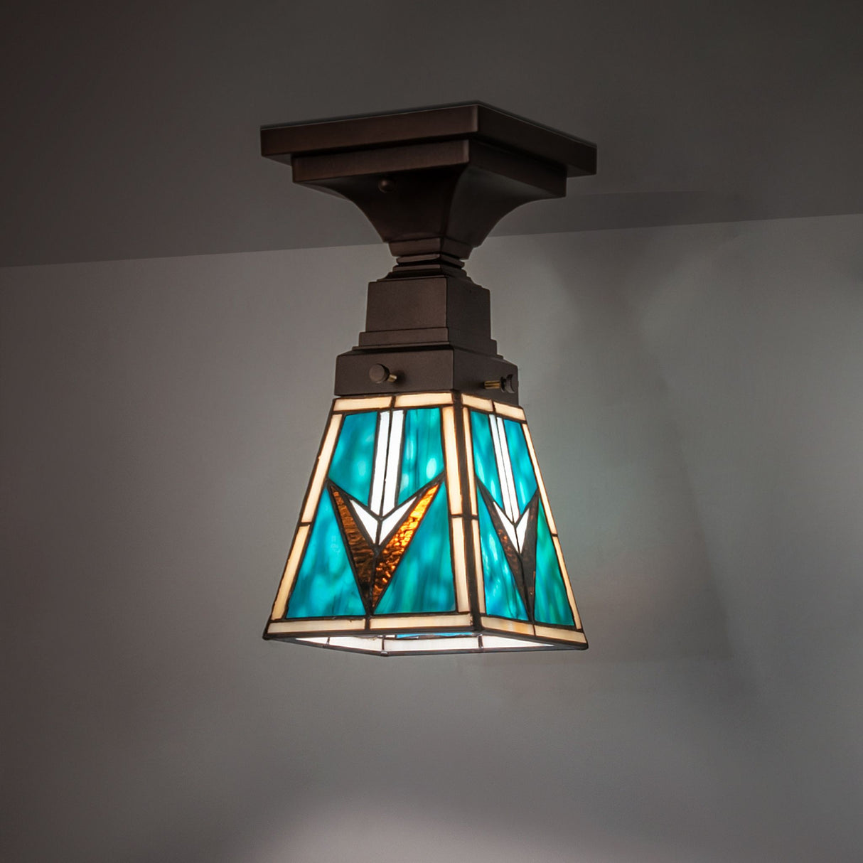 Illuminated view of the Valencia Mission Flushmount highlighting vibrant turquoise and beige glass.