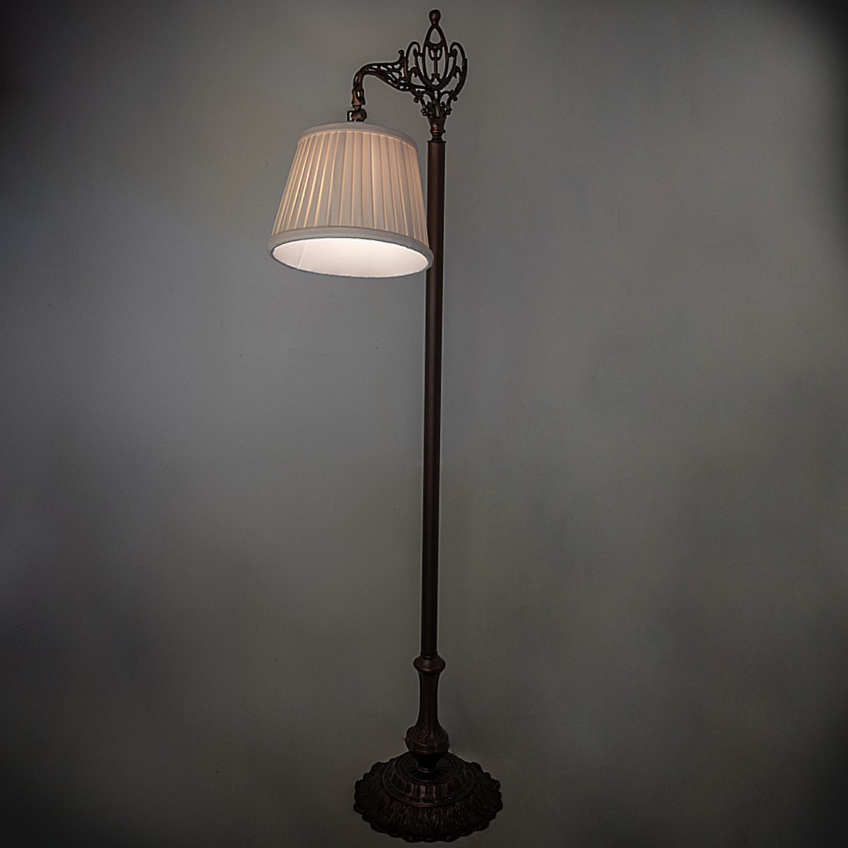 Victorian bridge arm lamp softly glowing in ambient lighting.