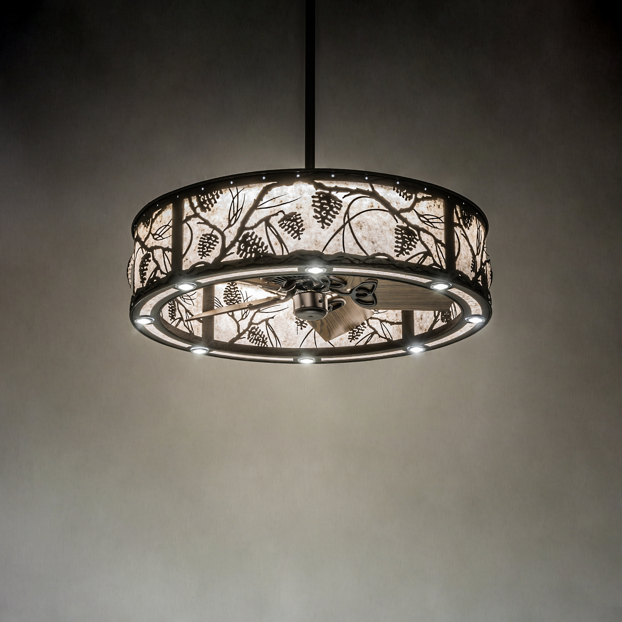Whispering Pines chandelier fan softly illuminated in dark room.