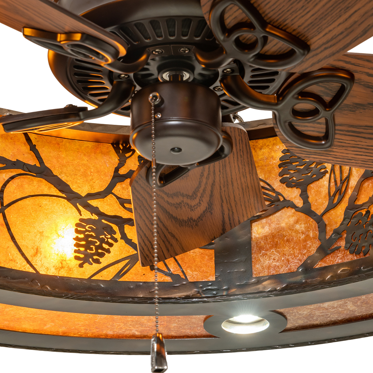 Closeup of fan housing and pull chain with pinecone pattern glowing in background.