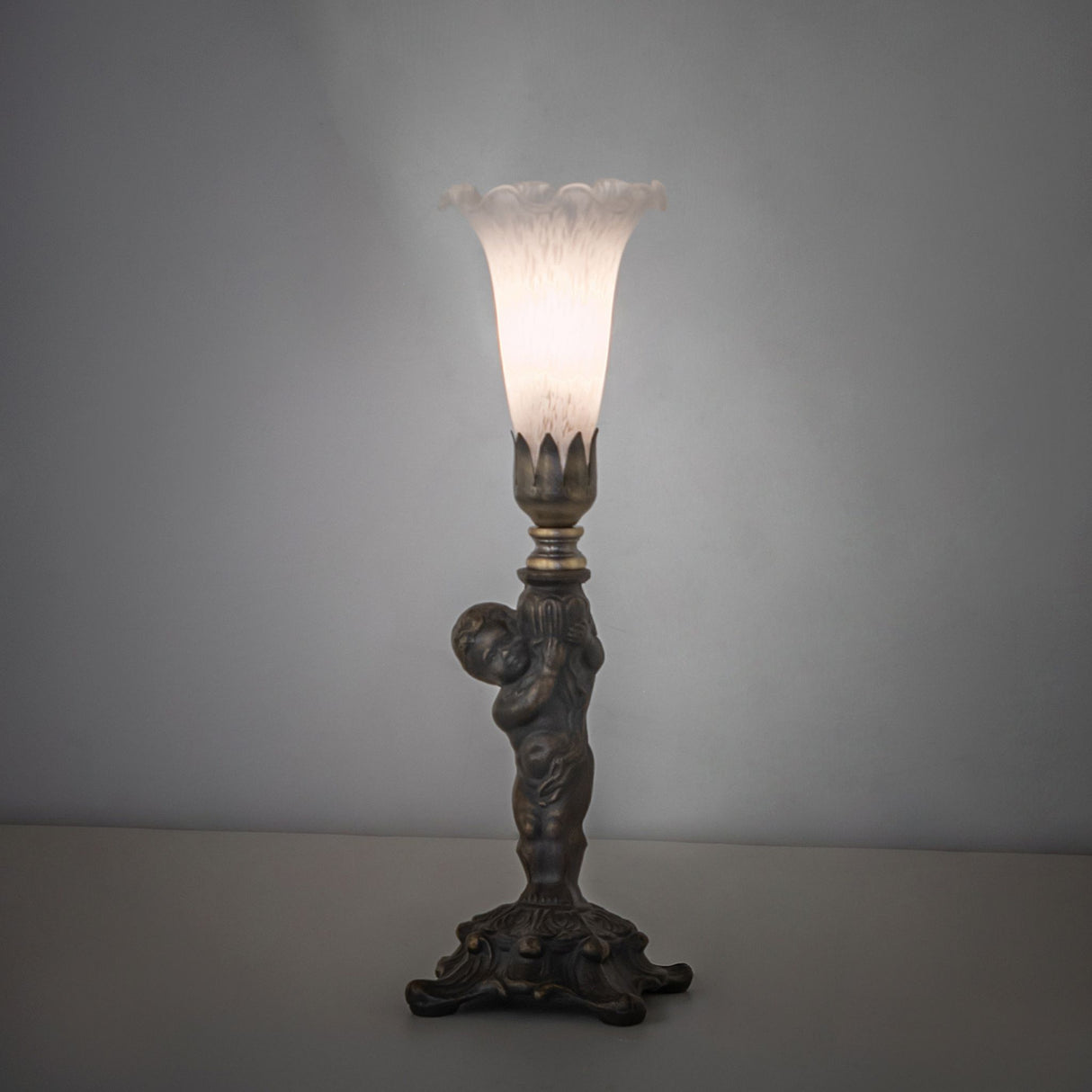 White Tiffany cherub mini lamp glowing softly in ambient light.