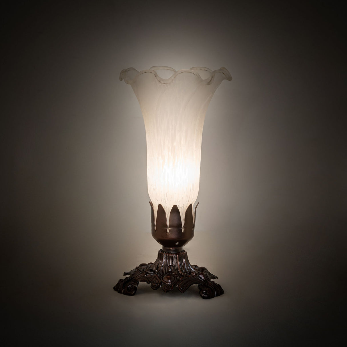 White Tiffany Pond Lily Victorian Accent Lamp glowing softly in a dim setting.