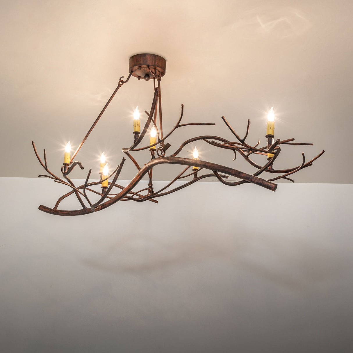 Nature-inspired branch chandelier creating warm ambient lighting in a room.